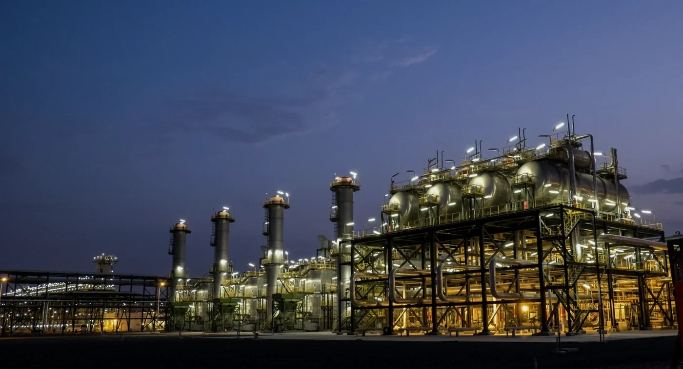 Gas processing plant at dusk — separator train, process columns and pipe racks